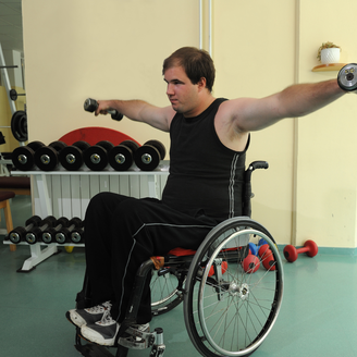 Man in wheelchair exercising using weights, doing a lateral raise