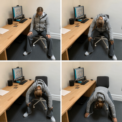 Seated near a desk the woman in flexing her spine to rolldown and reach towards the floor